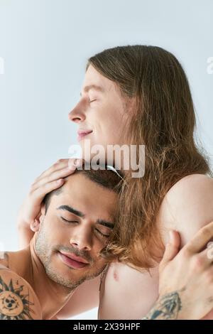 A man tenderly holds his boyfriend in his arms. Stock Photo