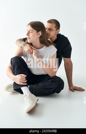 Two men sit closely together, sharing a moment of connection. Stock Photo