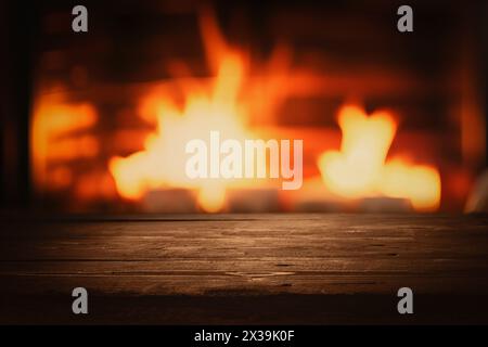 empty dark brown wooden tabletop for product display on blurred wood burning fireplace background Stock Photo