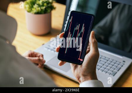 man looking at online crypto or stock market data charts on mobile phone. blockchain digital asset and ETF investment concept Stock Photo