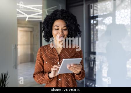 Young and successful female programmer, portrait of female engineer with tablet computer startup worker working inside office building using tablet for testing applications smiling . Stock Photo