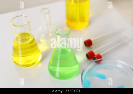 Laboratory analysis. Different glassware with liquids on white table Stock Photo