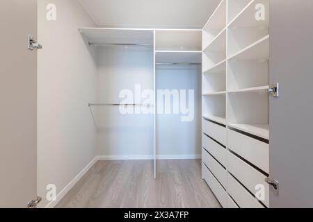 A Small White Walk in Closet With Shelves. Home Interior. Stock Photo