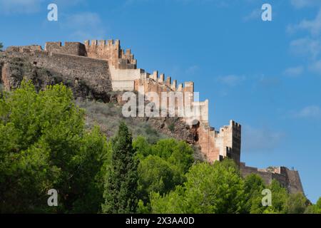 View of the castle in Sagunt, showcasing thick walls, a large gate, partially ruined buildings and foundations Stock Photo