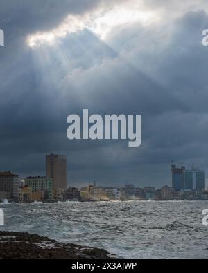 Shafts of sunlight breaking through the dark storm clouds over Havana Cuba Stock Photo