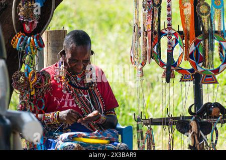 An adult African woman from the Maasai tribe sells jewelry in her shop on the street. Amboseli National Park, Kenya. February 5, 2024. Stock Photo