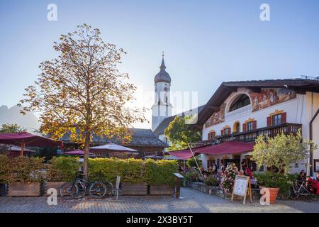 Restaurant and beer garden Fischers Mohrenplatz with parish church St. Martin and Wetterstein mountains in autumn in the evening light, district Stock Photo