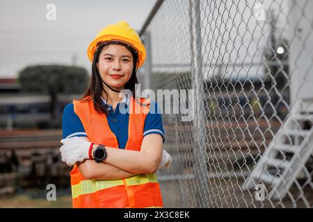 portrait train locomotive engineer women worker. Happy Asian young teen smiling work at train station train track locomotive service maintenance. Stock Photo