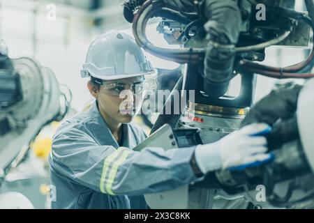 Engineer working machine assembly in advance technology robotic factory industry, Service maintenance robot arm cable part Stock Photo