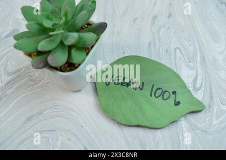 Concept of Vegan 100% write on sticky notes isolated on Wooden Table. Stock Photo