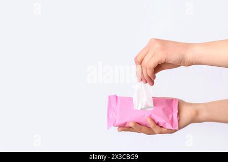 Female hands with pack of wet tissues on white background Stock Photo