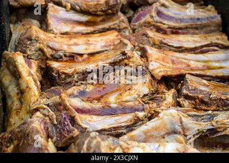 Many seasoned and marinated beef short ribs side by side, preparation for a large barbecue party, selected focus, narrow depth of field Stock Photo