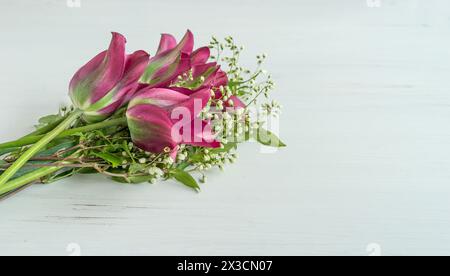 Bouquet of pink and green tulips and branches with white flowers on a white background Stock Photo