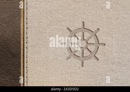 Brown buddhist design with leather and fabric texture with wheel of dharma engraved. Top view. Stock Photo