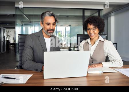 Diverse business work team people looking at laptop working together in office. Stock Photo