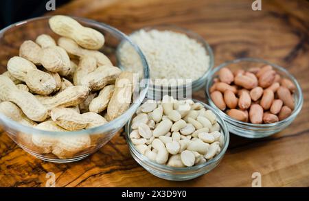 ground-nut, peanut (Arachis hypogaea), peanuts with and without shells, peeled and chopped in bowls Stock Photo