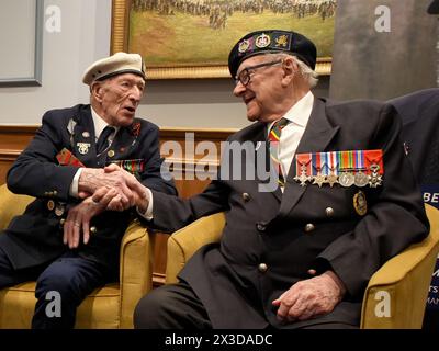 D-Day veterans Alec Penstone (left), 98, who served with the Royal Navy, shakes hands with Ken Hay, 98, Ambassador for the British Normandy Memorial who served with the 4th Dorset Regiment, at the D-Day 80 launch event organised by the Spirit of Normandy Trust, in conjunction with the British Normandy Memorial, at the Union Jack Club in London. The event is one of the largest UK gatherings of D-Day and Normandy veterans for many years, and brings together some of the last remaining members of what is known as The Greatest Generation. Picture date: Friday April 26, 2024. Stock Photo