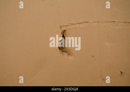 Brown corrugated cardboard with a hole texture useful as a background - retro vintage effect. Stock Photo