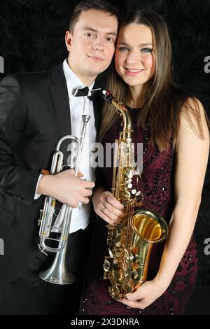 Portrait of happy musicians with wind instruments in their hands on a black fur ground Stock Photo
