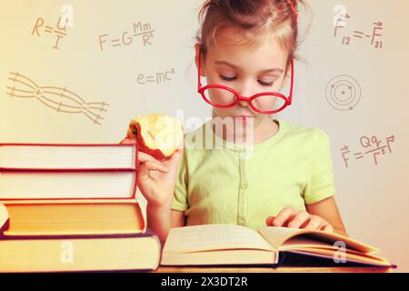 Girl in glasses studies physics from a book, collage Stock Photo