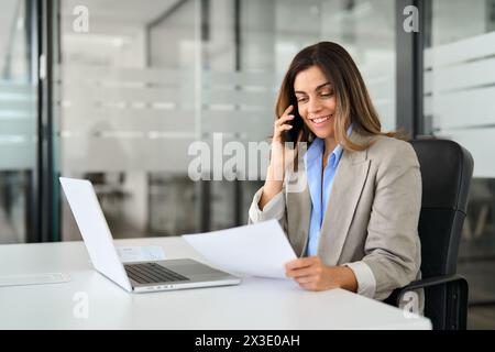Happy professional woman executive making call talking on phone at work. Stock Photo