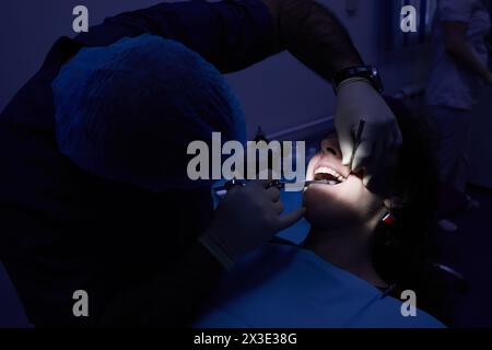 Dentist makes anesthetic injection in gum of woman before tooth healing. Stock Photo