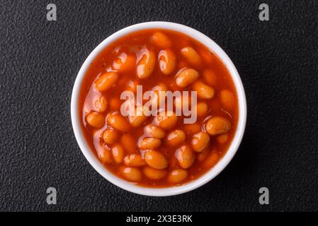 Delicious nutritious canned beans in tomato, with salt and spices as a high-calorie breakfast addition Stock Photo