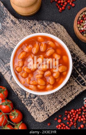 Delicious nutritious canned beans in tomato, with salt and spices as a high-calorie breakfast addition Stock Photo