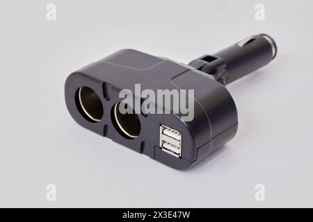 Dual socket car lighter charger with two usb ports on white background. Stock Photo