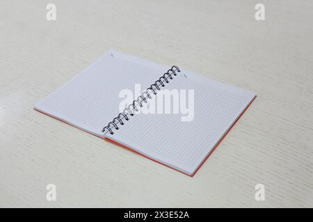 Squared notebook lying on table. Stock Photo