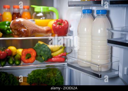 Products in the refrigerator. Bottles of milk in the fridge Stock Photo