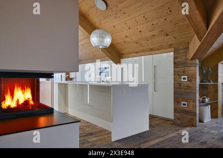 interior view of a modern white island kitchen in the rustic attic room Stock Photo
