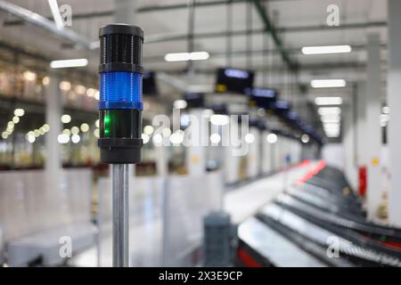 Empty workshop with conveyor, many displays in warehouse, focus on lamp Stock Photo