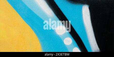 Fragment of old plaster wall with graffiti painting. Part of colorful street art graffiti on wall background. Youth, urban culture. Black, light blue Stock Photo