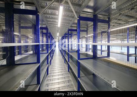 Big empty warehouse with many shelves - long hallway in sorting center Stock Photo