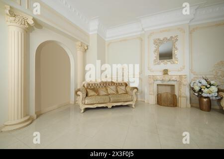 Empty baroque studio with beautiful couch, fireplace, flowers and molding on walls Stock Photo