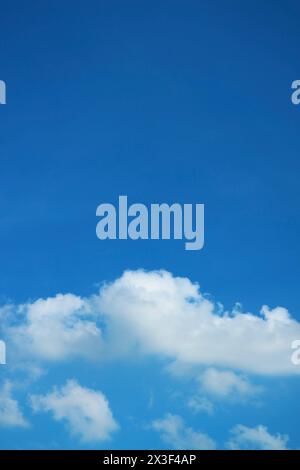 White Fluffy Clouds Floating on Vivid Blue Sky Stock Photo