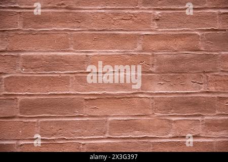 Red structural stone wall of building consists of old little bricks. Nature structural background. Stock Photo