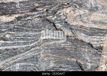 Full frame abstract texture background of the textured surface on a large striated granite rock Stock Photo