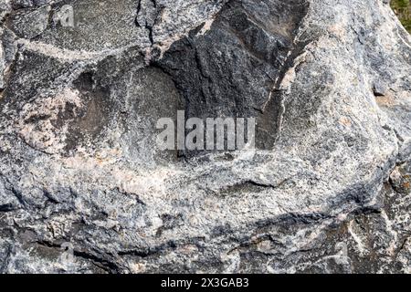 Full frame abstract texture background of the textured surface on a large striated granite rock Stock Photo