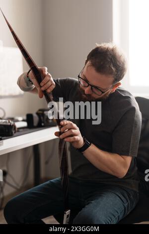 Photographer inspecting film negatives in a bright workspace Stock Photo