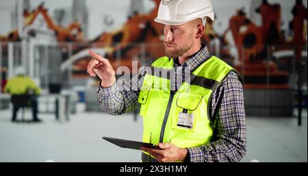 Workers In Automotive Car Factory Using Tablet Stock Photo