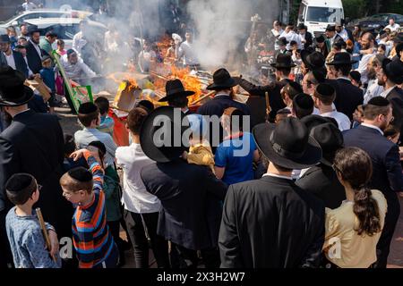 April 22, 2024, Bnei Brak, Israel: The Jewish Orthodox gather around the fire set to burn the leaven during the Biur Chametz. During the Biur Chametz, religious Jews fulfill their obligation to inspect their homes for any leaven and eliminate it before the night of Passover. In ultra-Orthodox cities in Israel, fires are set up in major locations in the city for this purpose, where people bring their bread leftovers to burn the leaven. During the seven days of Passover, they are prohibited from eating or possessing any leaven, symbolizing the dough the Israelites did not have time to allow to r Stock Photo