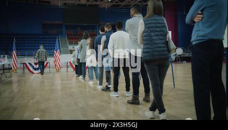 Vote here sign on the floor. Queue of multi ethnic American citizens come to vote in polling station. National Election Day in United States. Political races of US presidential candidates. Civic duty. Stock Photo