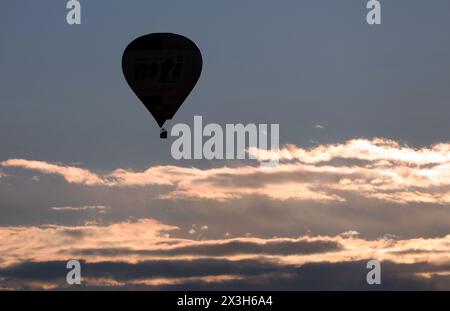 Pfronten, Germany. 27th Apr, 2024. A hot air balloon glides over the Alpine foothills in the early morning. Credit: Karl-Josef Hildenbrand/dpa/Alamy Live News Stock Photo