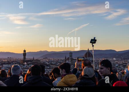 Crowds of tourists at Piazzale Michelangelo in Florence in Tuscany, Italy at sunset. Classic view of the Cathedral - Duomo - and Palazzo Vecchio. Stock Photo