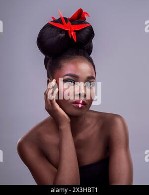 Black woman, studio and portrait with origami for beauty, traditional or creative with cosmetics. Female model, gray background and paper design with Stock Photo