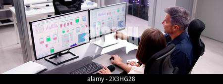 Two people working together on computer engineering screen environment Stock Photo