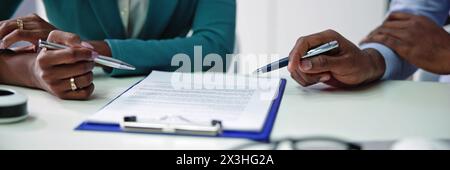 Reviewing business contract document with two hands involved Stock Photo