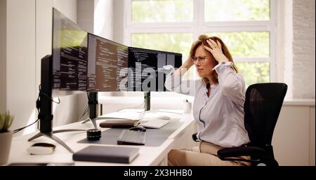 Unhappy Sad Developer Programmer Woman In Stress Coding Software On Computer Stock Photo